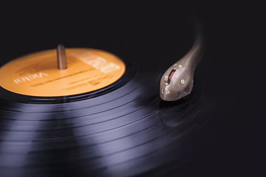 A close-up of a vinyl record with a pick-up resting on its surface